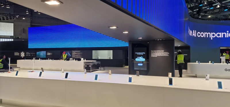 Technicians installing white modular counters under blue-lit framework – Exhibition stand build