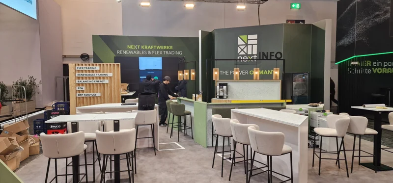 Exhibition stand build showcasing modern counters, upholstered barstools, lighting fixtures and display walls