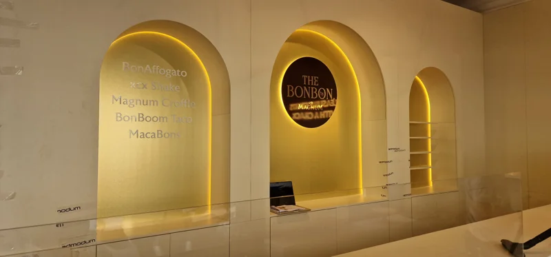 White wall with three LED-lit arched niches and central branded panel in exhibition stand build